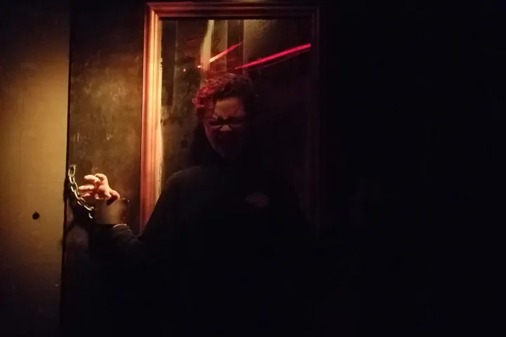 a man standing in front of a mirror in a dark room